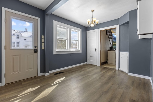 entrance foyer with an inviting chandelier, dark wood-type flooring, and plenty of natural light