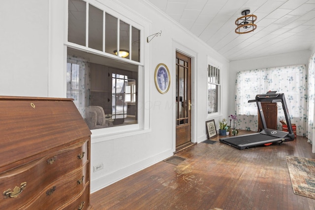 exercise room with crown molding and wood-type flooring