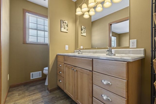 bathroom with toilet, vanity, and hardwood / wood-style floors