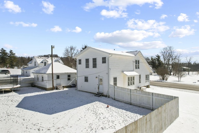 snow covered house featuring a trampoline