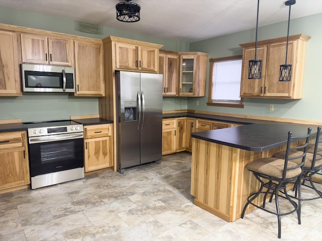 kitchen featuring appliances with stainless steel finishes, a kitchen breakfast bar, pendant lighting, and kitchen peninsula