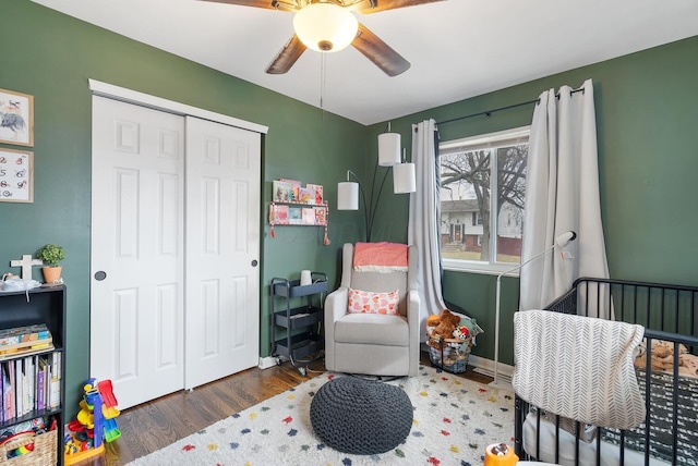 bedroom with a closet, ceiling fan, baseboards, and wood finished floors