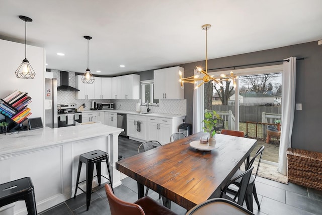 dining space featuring dark tile patterned flooring, an inviting chandelier, and recessed lighting