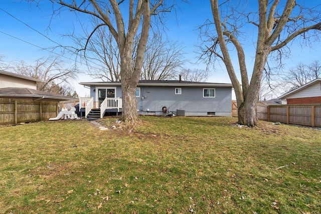 back of house featuring fence, central AC unit, and a lawn