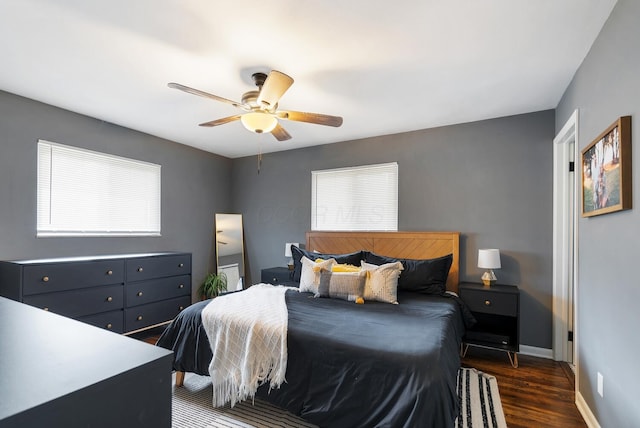 bedroom with dark wood-style floors, ceiling fan, and baseboards