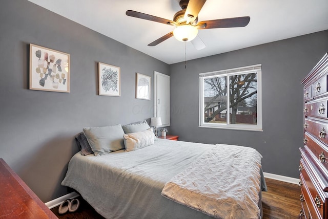 bedroom featuring dark wood-style floors, ceiling fan, and baseboards