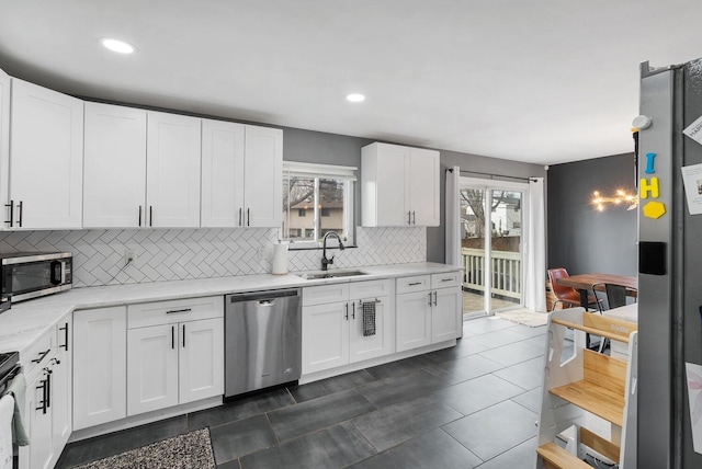 kitchen featuring tasteful backsplash, plenty of natural light, stainless steel appliances, and a sink