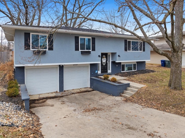 split foyer home featuring driveway, an attached garage, and brick siding