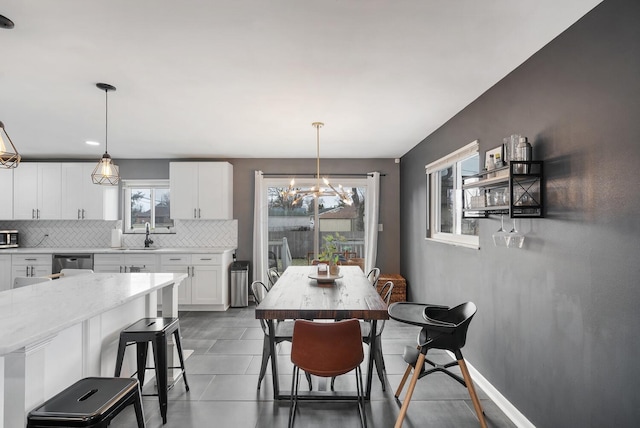 dining area featuring baseboards and a notable chandelier