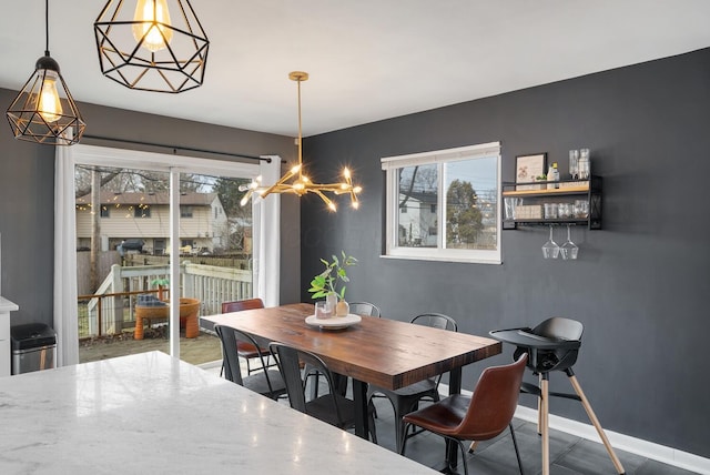 dining space featuring baseboards and a chandelier