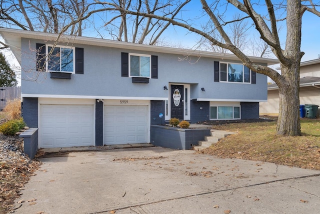 raised ranch with concrete driveway, brick siding, and an attached garage