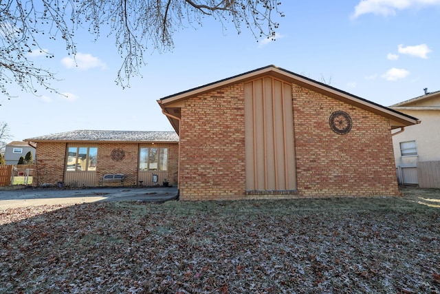 exterior space with brick siding and fence