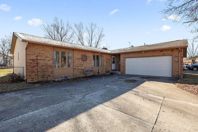 ranch-style house featuring brick siding, driveway, an attached garage, and fence