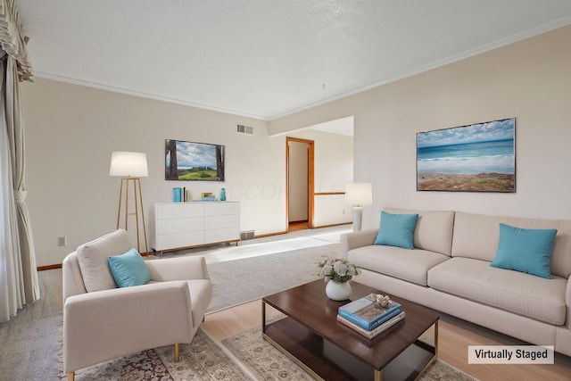 living room with visible vents, crown molding, light wood-style flooring, and baseboards