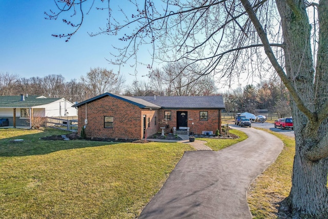 1545 E Choctaw Dr, London, OH 43140 - single story home featuring a front lawn, fence, brick siding, and driveway