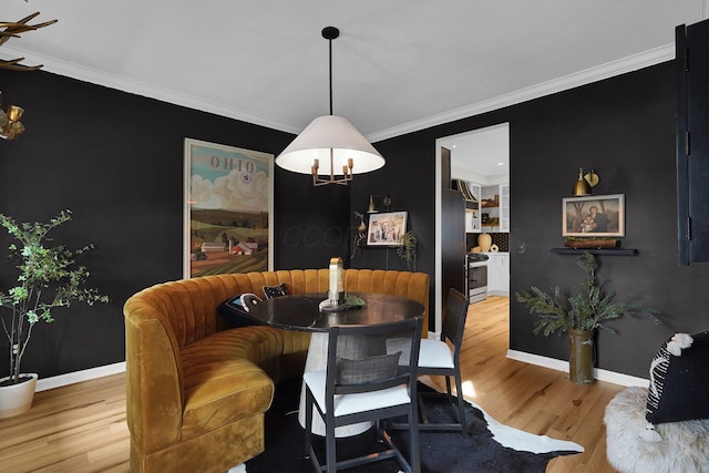 dining area featuring baseboards, wood finished floors, and crown molding