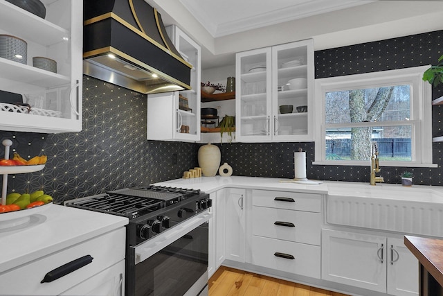 kitchen with a sink, open shelves, exhaust hood, and black gas stove