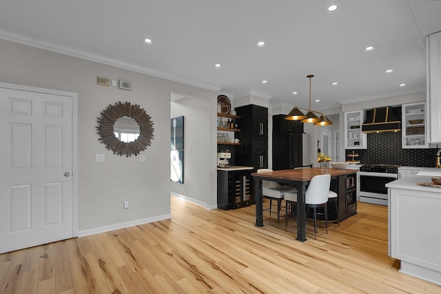 kitchen with range with gas cooktop, open shelves, custom range hood, wooden counters, and high end black fridge