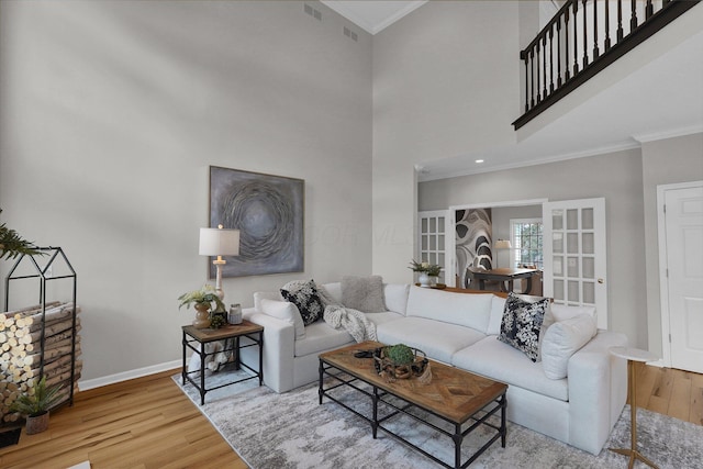 living area featuring baseboards, ornamental molding, and wood finished floors