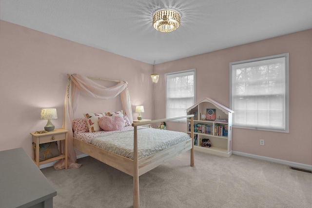 carpeted bedroom featuring visible vents and baseboards