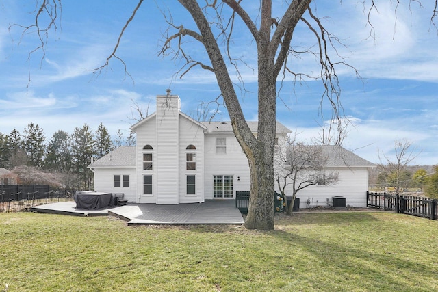 rear view of property featuring a fenced backyard, central air condition unit, a lawn, a wooden deck, and a chimney