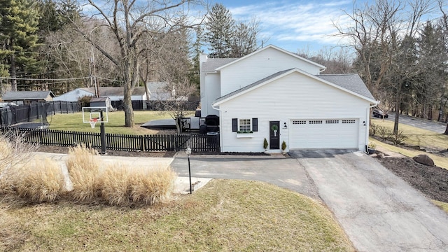 view of front of property with aphalt driveway, fence private yard, a front lawn, and a garage