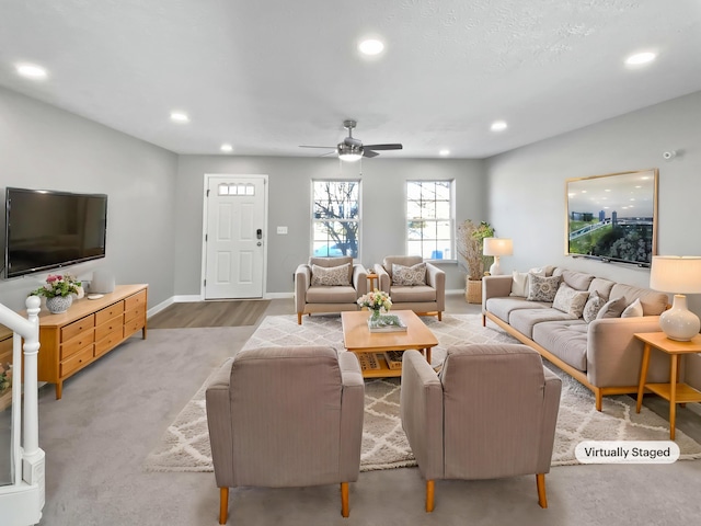 living room featuring baseboards, light wood-type flooring, a ceiling fan, and recessed lighting