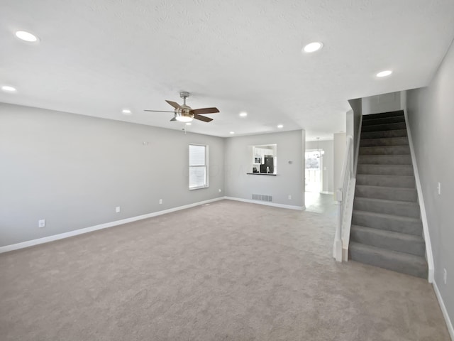 unfurnished living room featuring recessed lighting, baseboards, and stairs