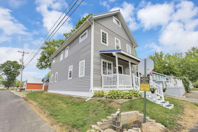 traditional style home featuring a porch, stairway, and a front yard