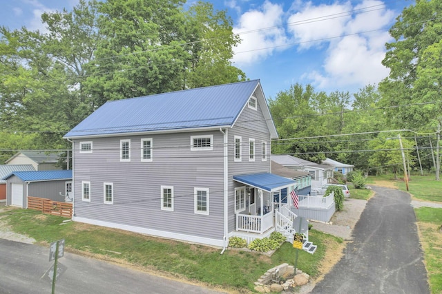 exterior space with a front yard, metal roof, and a detached garage