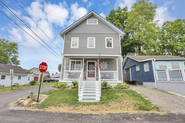 view of front of house with a porch, a front lawn, and stairs