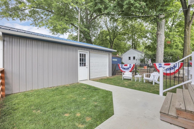 view of yard with a garage and an outbuilding