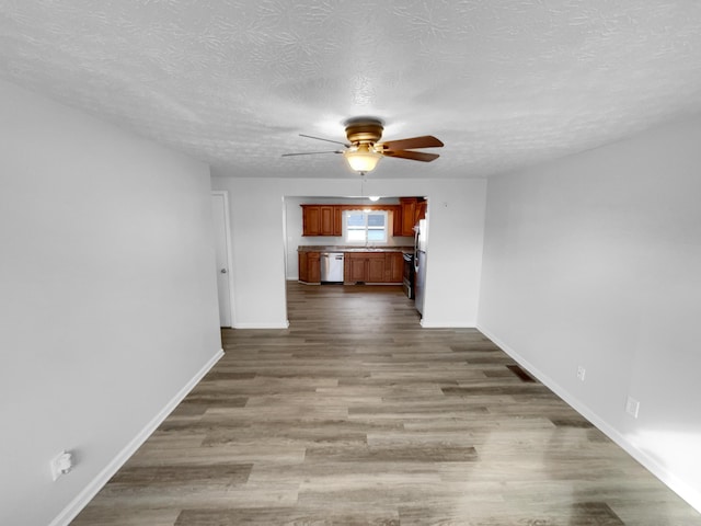 interior space featuring ceiling fan, wood-type flooring, and a textured ceiling