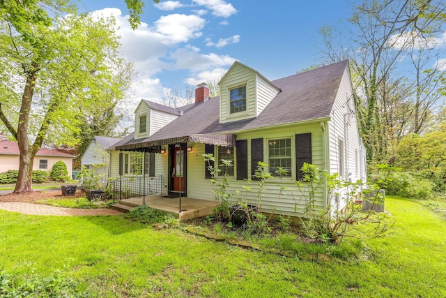 cape cod home featuring a front lawn, a chimney, and a shingled roof