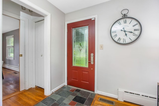 foyer entrance with a baseboard heating unit, baseboards, and dark wood-type flooring