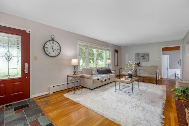 living area featuring healthy amount of natural light, a baseboard heating unit, wood finished floors, and baseboards