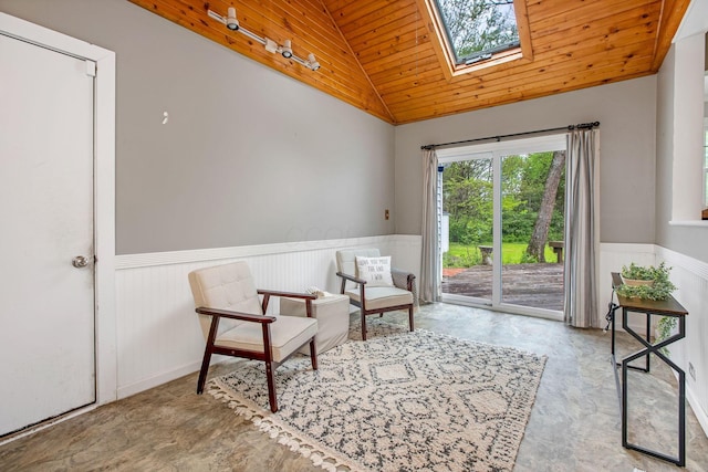 living area featuring wainscoting, lofted ceiling, wooden ceiling, and a skylight