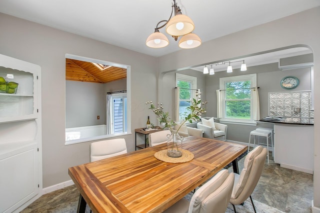 dining space featuring wooden ceiling, lofted ceiling, a skylight, and baseboards