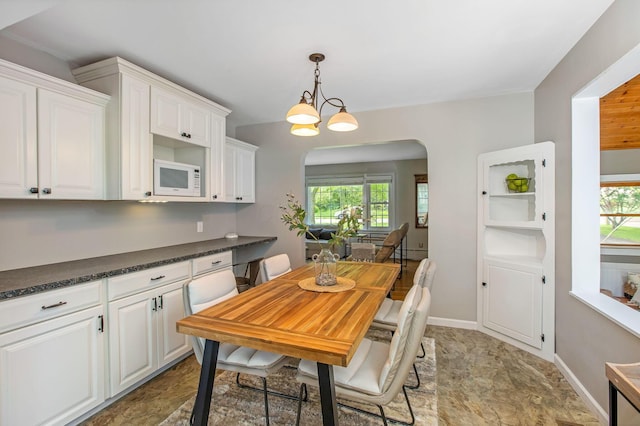 dining room featuring healthy amount of natural light and arched walkways