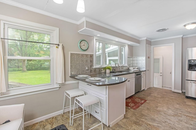 kitchen with stainless steel appliances, a sink, backsplash, a kitchen breakfast bar, and a peninsula