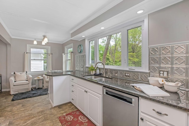kitchen featuring dishwasher, a sink, white cabinets, crown molding, and dark stone counters