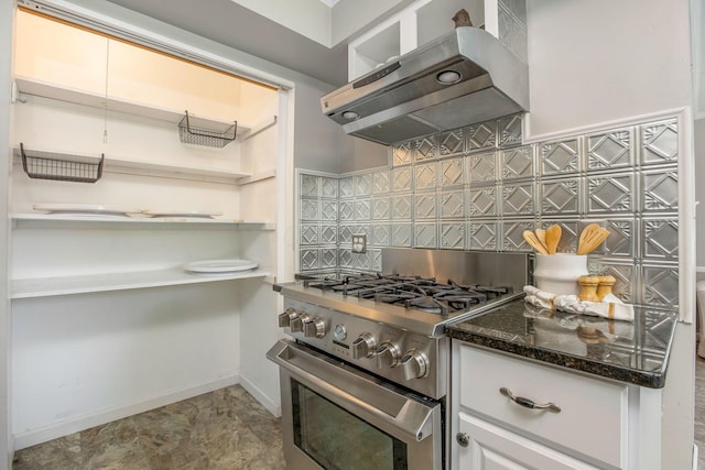 kitchen with high end stainless steel range, ventilation hood, tasteful backsplash, dark stone counters, and open shelves