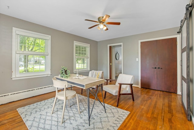 office with a ceiling fan, wood finished floors, baseboards, and baseboard heating