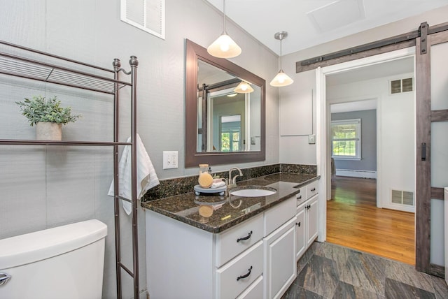 bathroom with toilet, vanity, and a baseboard heating unit