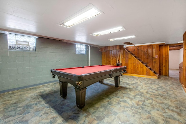 rec room with stone finish flooring, billiards table, wooden walls, and concrete block wall