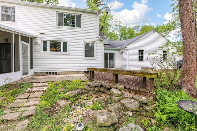 back of property featuring a sunroom and a wooden deck