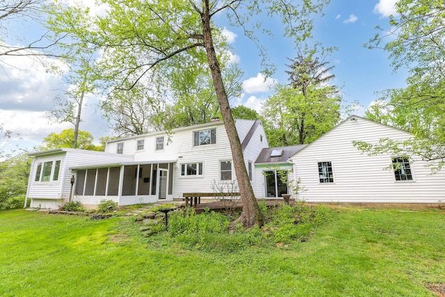 back of house with a sunroom and a lawn