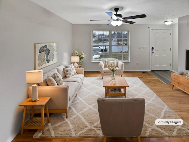 living area with ceiling fan, wood finished floors, and baseboards