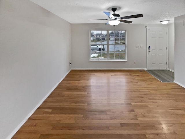 interior space with ceiling fan, wood-type flooring, and a textured ceiling