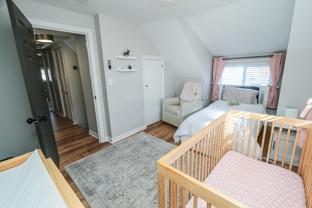 bedroom with vaulted ceiling and dark hardwood / wood-style floors